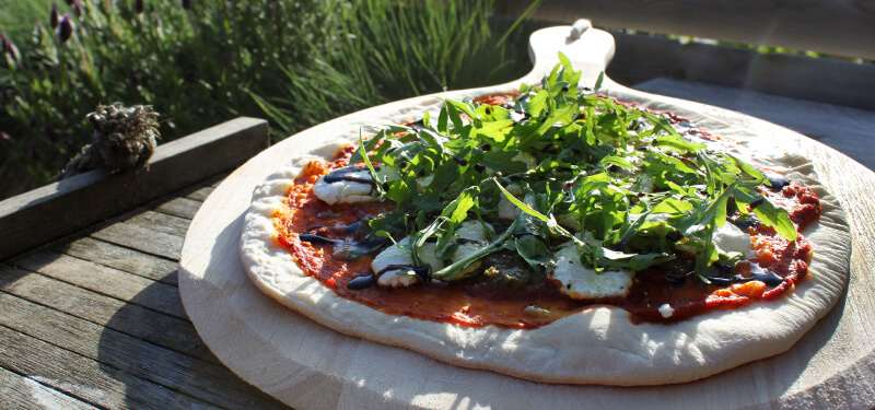 Breng Italië naar je eigen achtertuin met een pizzasteen en dit recept voor een heerlijke Pizza met geitenkaas!